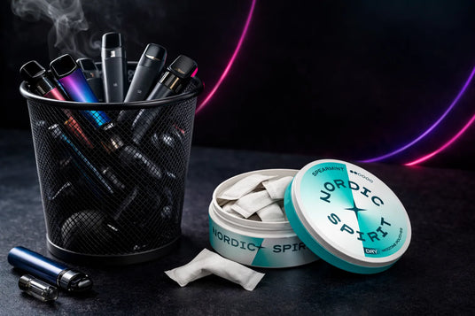 Vaping devices and Nordic Spirit products on a dark surface with smoke effect