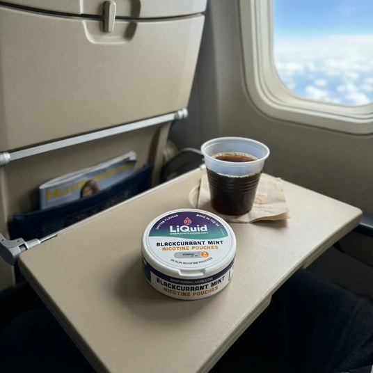 LiQuid Nicotine Pouches on an airplane tray table
