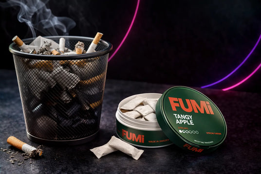 FUMI Tangy Apple cigarettes with a ashtray and smoking accessories on a dark background